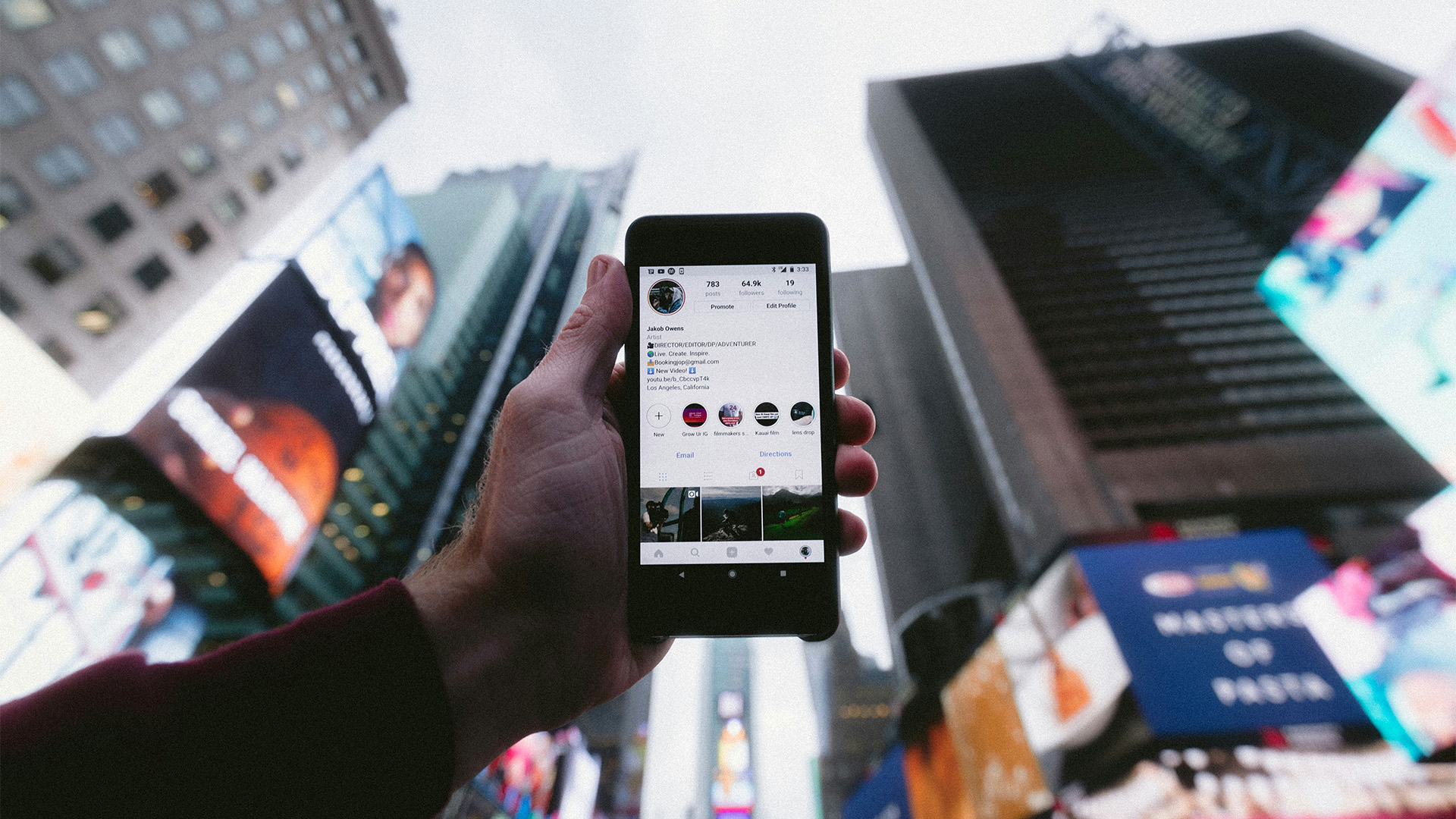 Sociala medier från avsändare till användare (illustreras med en person som håller upp en mobiltelefon mot stadshimlen)
