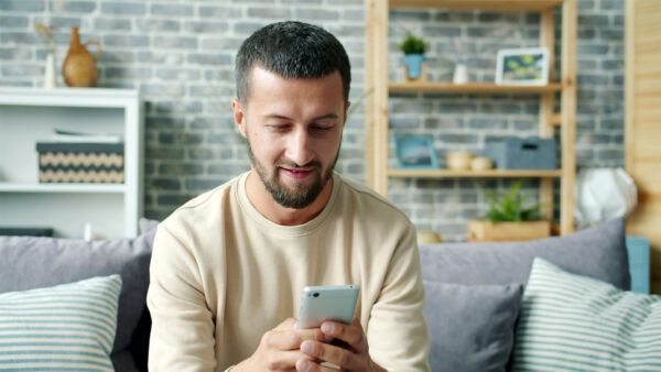 Tillgänglighet för dyslexi (man som sitter i en soffa och läser i mobilen)